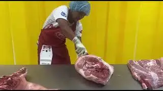 Bonnel Sabasales performing the deboning of a half-pork carcass.