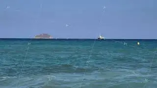 A stunningly beautiful ocean scene featuring a boat sailing near a picturesque island