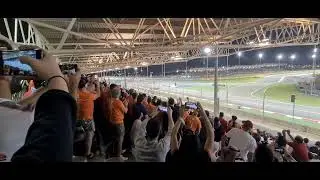 Max Verstappen vs. Charles Leclerc battle from the turn 1 grandstand in Bahrain with the orange army