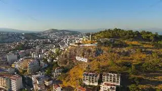 Kusadasi, Turkey. Large white KUSADASI letters against mountain slope. Summer morning shot showin...