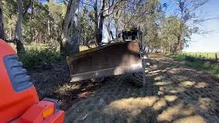 Grader with a rotating front blade.  Not a common attachment. Worth considering.
