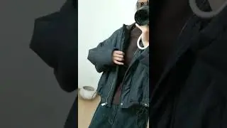 Cropped black hooded puffer bomber jacket layered over brown top