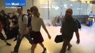 Taylor Swift in a corduroy Mini Skirt and midriff baring knit as she arrives at LAX