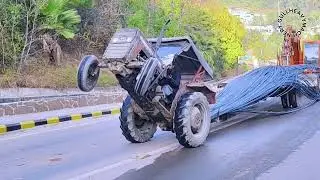 Old model tractor carrying steel rods climbing a steep slope — dangerous situation