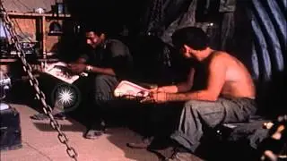 Two soldiers read magazines inside a dual blade bunker at Camp Carroll in Vietnam...HD Stock Footage
