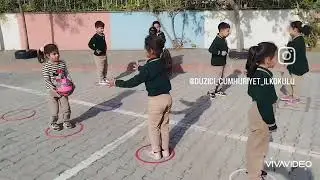 Eğitsel oyunlar. Sırasıyla halkalar içine geçip arkadaşına topu atıp ilk bitiren grup kazanır