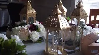 Centros de mesa con linterna y flores artificiales.