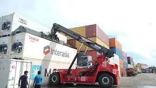 Kalmar Reach stacker with a tilting spreader for container handling.