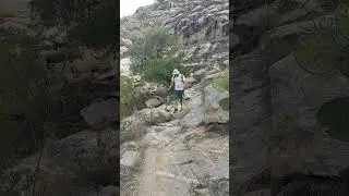 Use of walking sticks by lower leg amputee to traverse rocky trail in Coronado National Forest, AZ.