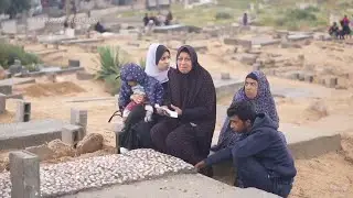 Grieving relatives spend the first morning of Eid al-Fitr at Deir Al-Balah cemetery