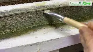 Painting moss and algae on a stone retaining wall