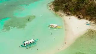 Small torpic island with a white sandy beach, top view.