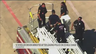 Police chase ends with man clinging to trailer of 18-wheeler