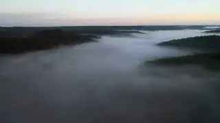 Drone flying over a misty and cloudy forest valley in Australia