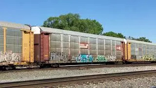 A BNSF H1 Dash 9CW leads a Westbound BNSF Auto Rack at BlueIsland on the IHB.
