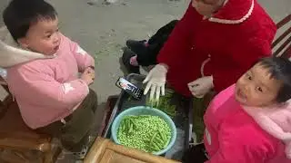 Amy and Anna help their mom shell the peas.