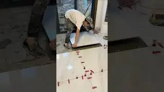 the process of installing plain white ceramic tiles on the floor of a large house #construction