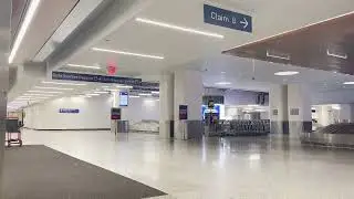 an empty airport baggage claim at 1 am with classical music playing in the background
