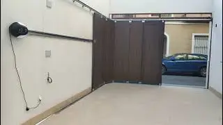 Puerta seccional de apertura lateral, imitaci&oacute;n madera oscura. Instalaci&oacute;n de motor techo lateral.