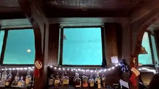 Mermaid spins upside down with a holiday toy at The Wreck Bar and Johnny