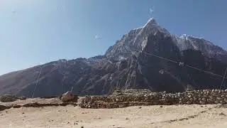 Drone shot of an isolated Nepali village in the Himalayas, featuring traditional homes and towering