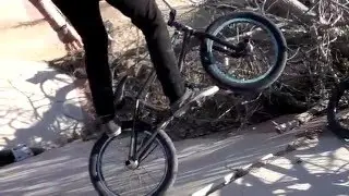 Devon Lampman rides his bike on a broken bridge.