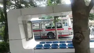 Buses in Action: A Timely Wait Near NHK Science & Technology Labs in Tokyo