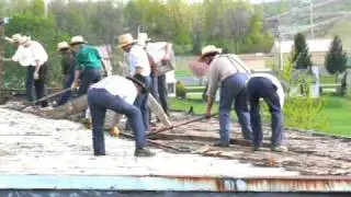 Amish crew remove roof of building