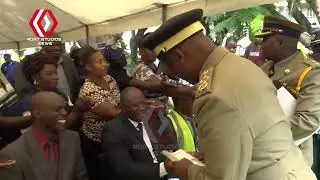 ZRP Commissioner-General Stephen Mutamba handing out Client Service Charter handbooks