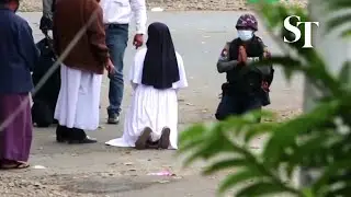Myanmar nun kneels between police and protesters