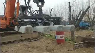 Railway track laying machine - excavator attachment