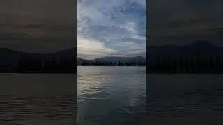 Sunset lights up mountains with a giant clock towering in the sky