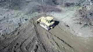 Caterpillar High Track Dozer Pushing Dirt - drone view