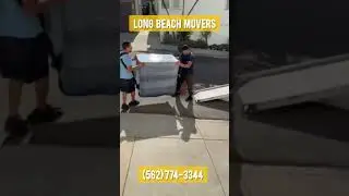 Long Beach Movers moving a heavy dresser by using shoulder straps.