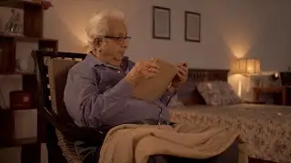 Shot of a retired Indian man reading a book sitting on a rocki... | Indian Stock Footage | Knot9