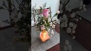 Table flower display on light base
