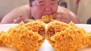 The monkey was very satisfied eating a whole bag full of fried chicken pieces.