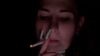 A girl with long nails smokes cigarettes and throws the butt on the floor