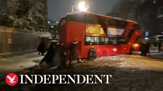 Londoners band together to move bus stuck during heavy snowfall