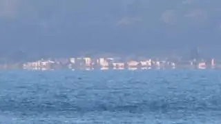 Inferior mirage of the Sun reflecting from windows of distant houses