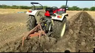 VST TRACTOR Demo heavy ploughing in field.