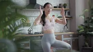 Healthy asian yoga woman doing yoga in tree pose at home