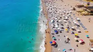 Dolly zoom. Oludeniz, Turkey. Low backward aerial drone flight over crowded Oludeniz Beach, peopl...