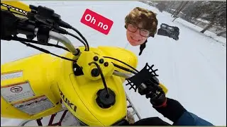 Fat white guy slips on snow riding a Suzuki LTZ400