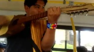 Dos jóvenes tocando en el bus Música Andina
