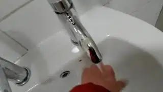 Unbranded sink with push tap and brand new cannon hygiene hand dryer at beamish museum in County Dur