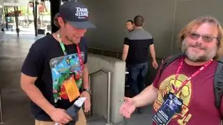 Jack Black catchs up with a fan wearing a Tenacious D tee shirt.