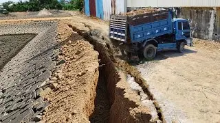 New, Cracked Road, Construction of a road over a lake using a SHANTUI bulldozer.