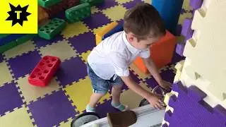 Тёма играет на детской площадке с игрушками и прыгает на батуте