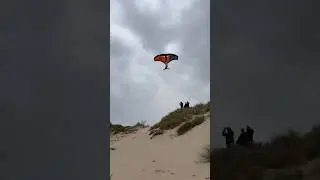 Winger jumping high on beach #wingfoil #wingfoiling